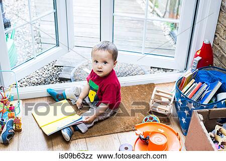 Stock Photo - Baby boy sitting on door mat. Fotosearch