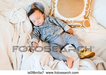 Stock Photo - Baby boy wearing hoody asleep on blanket. Fotosearch