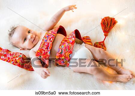 Baby boy wrapped in colourful textile lying on furry rug View Large Photo Image Stock Image - Baby boy wrapped in colourful textile lying on furry rug. Fotosearch