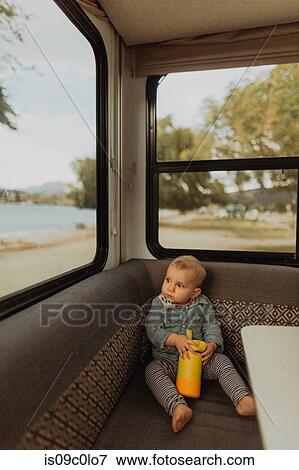 Stock Photo - Baby relaxing in motorhome, Wanaka, Taranaki, New Zealand. Fotosearch