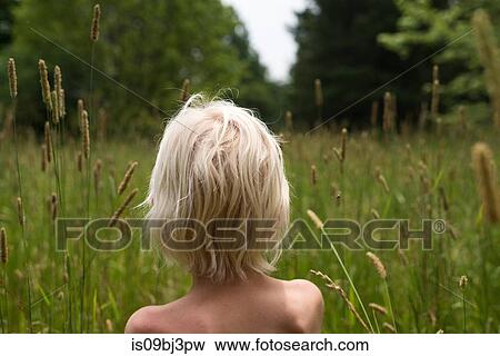 Bare shouldered blond haired boy in looking out at forest from long grass, rear view View Large Photo Image Stock Photo - Bare shouldered blond haired boy in looking out at forest from long grass, rear view. Fotosearch