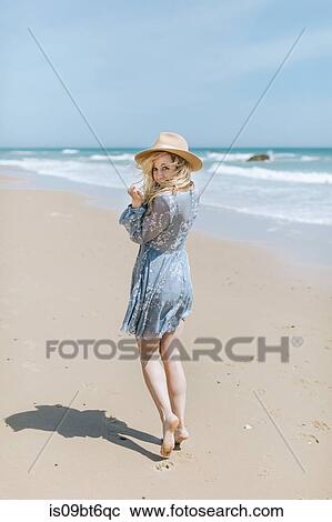 Stock Image - Barefoot young woman on windy beach, portrait, Menemsha, Martha's Vineyard, Massachusetts, USA. Fotosearch