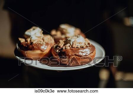 Barista carrying plate of chocolate doughnuts in cafe, cropped close up View Large Photo Image Stock Image - Barista carrying plate of chocolate doughnuts in cafe, cropped close up. Fotosearch