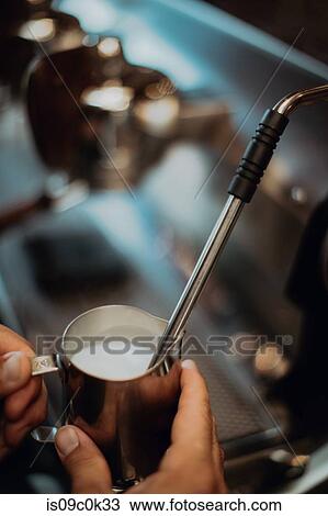 Barista heating jug of milk on coffee machine in cafe, close up of hand View Large Photo Image Stock Image - Barista heating jug of milk on coffee machine in cafe, close up of hand. Fotosearch