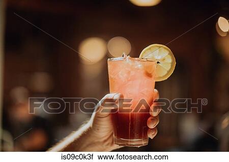 Barista holding up glass of fresh iced fruit juice in cafe, close up of hand View Large Photo Image Stock Image - Barista holding up glass of fresh iced fruit juice in cafe, close up of hand. Fotosearch