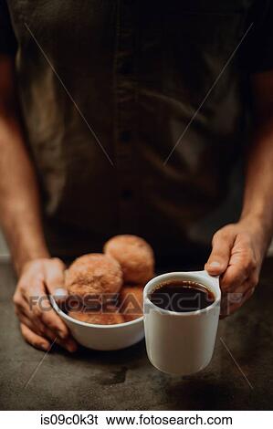 Barista placing black coffee and doughnuts on cafe counter, cropped shallow focus View Large Photo Image Stock Photograph - Barista placing black coffee and doughnuts on cafe counter, cropped shallow focus. Fotosearch