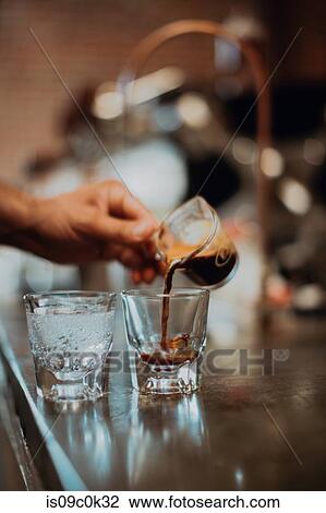 Barista pouring fresh coffee into drinking glass on cafe counter, detail of hand View Large Photo Image Stock Image - Barista pouring fresh coffee into drinking glass on cafe counter, detail of hand. Fotosearch