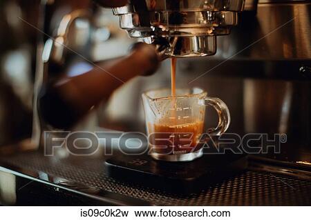 Barista pouring fresh coffee into measuring jug on coffee machine in cafe, shallow focus View Large Photo Image Stock Photo - Barista pouring fresh coffee into measuring jug on coffee machine in cafe, shallow focus. Fotosearch
