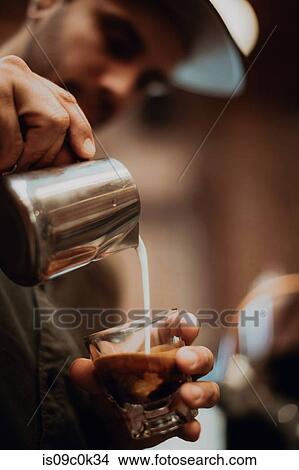 Barista pouring milk into coffee glass in cafe, close up of hands View Large Photo Image Picture - Barista pouring milk into coffee glass in cafe, close up of hands. Fotosearch
