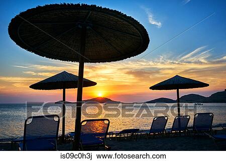 Beach umbrellas and sun loungers at sunset, Limnos, Khios, Greece View Large Photo Image Stock Image - Beach umbrellas and sun loungers at sunset, Limnos, Khios, Greece. Fotosearch