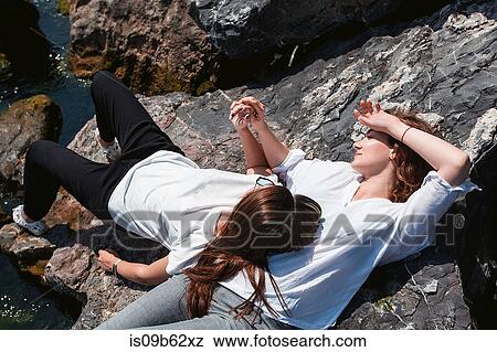 Best friends relaxing on rocks View Large Photo Image Stock Photo - Best friends relaxing on rocks. Fotosearch