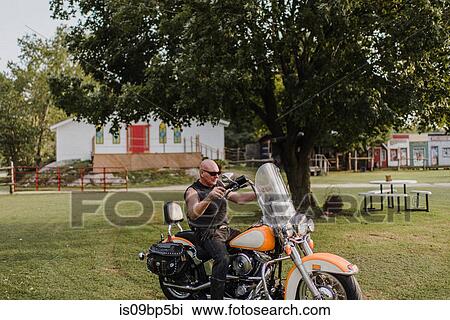 Biker on his bike on lawn View Large Photo Image Stock Image - Biker on his bike on lawn. Fotosearch