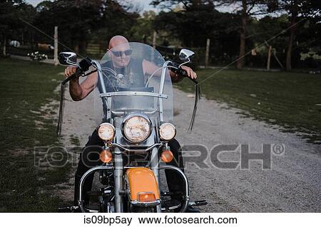 Biker on his bike on lawn View Large Photo Image Stock Photo - Biker on his bike on lawn. Fotosearch