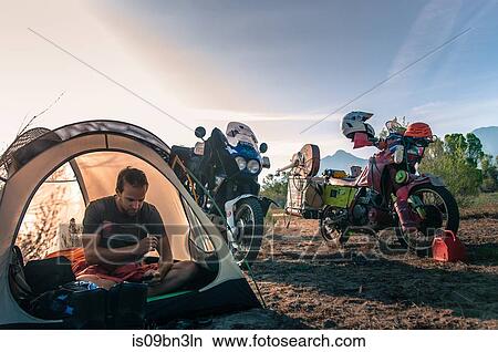Biker using mobile phone inside tent, Fresno, California, USA View Large Photo Image Picture - Biker using mobile phone inside tent, Fresno, California, USA. Fotosearch