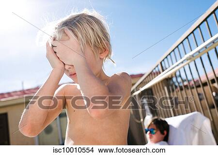 Blond haired boy covering eyes with hands at hotel poolside, Las Vegas, Nevada, USA View Large Photo Image Picture - Blond haired boy covering eyes with hands at hotel poolside, Las Vegas, Nevada, USA. Fotosearch