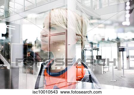 Stock Image - Blond haired boy gazing through window in airport, head and shoulders. Fotosearch