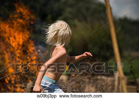 Blond haired boy running away from garden bonfire View Large Photo Image Stock Photography - Blond haired boy running away from garden bonfire. Fotosearch
