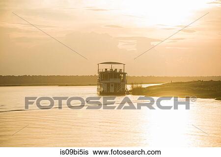 Boat on river at sunset, Chobe National Park, Botswana View Large Photo Image Stock Photograph - Boat on river at sunset, Chobe National Park, Botswana. Fotosearch
