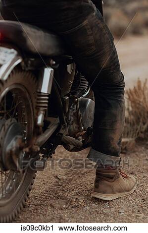 Booted leg of man on motorbike View Large Photo Image Stock Image - Booted leg of man on motorbike. Fotosearch