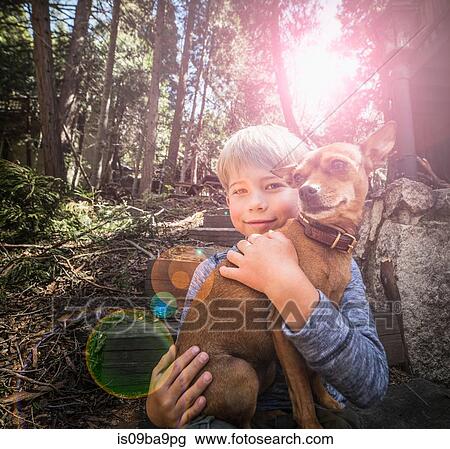 Boy carrying dog in woods View Large Photo Image Stock Image - Boy carrying dog in woods. Fotosearch