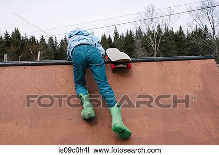 Boy clambering to top of skateboard ramp, rear view View Large Photo Image Stock Image - Boy clambering to top of skateboard ramp, rear view. Fotosearch