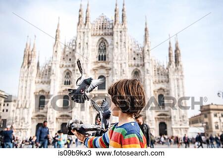 Boy feeding pigeons in Milan Cathedral square, Milan, Lombardy, Italy View Large Photo Image Stock Image - Boy feeding pigeons in Milan Cathedral square, Milan, Lombardy, Italy. Fotosearch