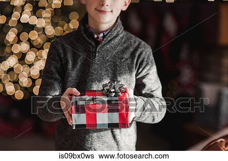 Boy holding Christmas gift View Large Photo Image Stock Photograph - Boy holding Christmas gift. Fotosearch