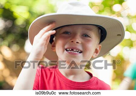 Stock Image - Boy in hat on sunny day in forest. Fotosearch