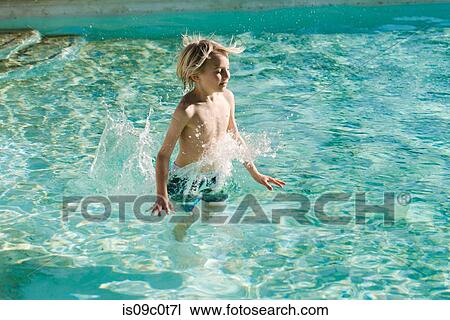Stock Image - Boy jumping into swimming pool. Fotosearch