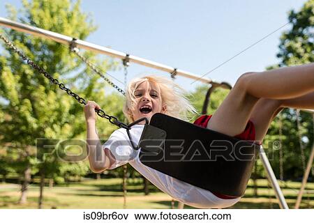 Boy on swing in park View Large Photo Image Stock Photo - Boy on swing in park. Fotosearch