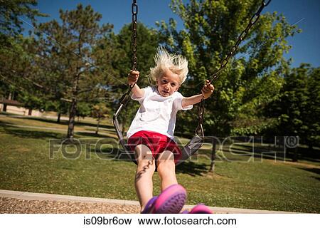 Boy on swing in park View Large Photo Image Stock Photo - Boy on swing in park. Fotosearch