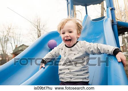 Boy playing on slide View Large Photo Image Stock Photograph - Boy playing on slide. Fotosearch