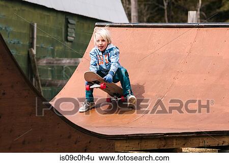 Boy preparing to sit down on skateboard on wooden skateboard ramp View Large Photo Image Stock Photograph - Boy preparing to sit down on skateboard on wooden skateboard ramp. Fotosearch