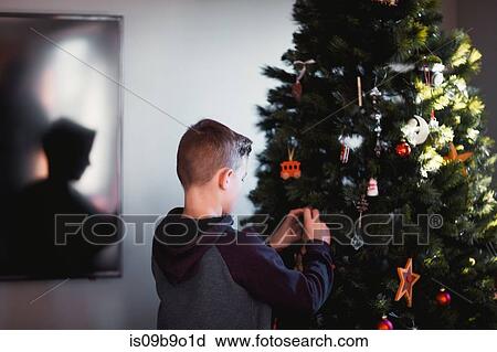 Stock Image - Boy putting up Christmas decorations. Fotosearch