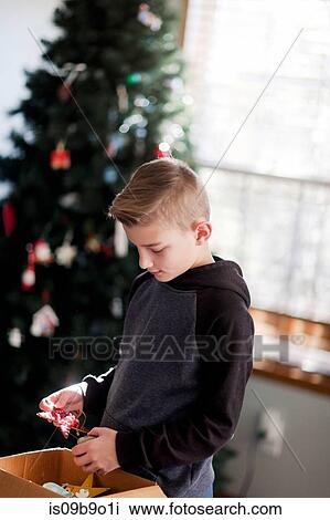 Boy putting up Christmas decorations View Large Photo Image Stock Image - Boy putting up Christmas decorations. Fotosearch