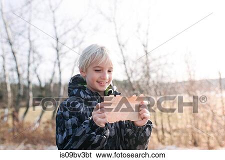 Stock Photograph - Boy reading clue note in countryside. Fotosearch