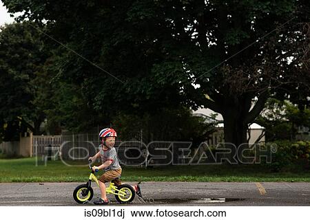Boy riding bicycle on wet road View Large Photo Image Stock Image - Boy riding bicycle on wet road. Fotosearch