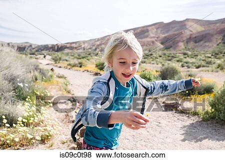 Boy running with flower in hand, Red Rock Canyon, Cantil, California, United States View Large Photo Image Stock Photo - Boy running with flower in hand, Red Rock Canyon, Cantil, California, United States. Fotosearch