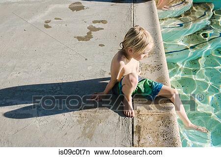 Boy sitting by swimming pool View Large Photo Image Picture - Boy sitting by swimming pool. Fotosearch