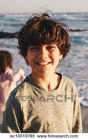 Boy smiling on beach, sister in background View Large Photo Image Stock Photography - Boy smiling on beach, sister in background. Fotosearch