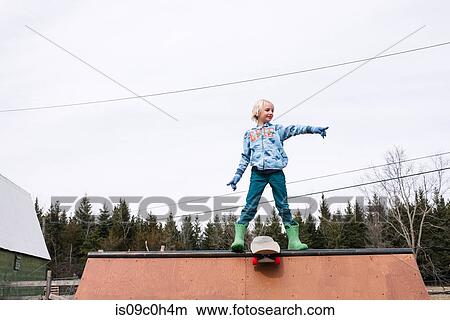 Boy standing on top of skateboard ramp pointing View Large Photo Image Picture - Boy standing on top of skateboard ramp pointing. Fotosearch