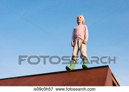 Boy standing on top of skateboard ramp against blue sky, low angle view View Large Photo Image Stock Photo - Boy standing on top of skateboard ramp against blue sky, low angle view. Fotosearch