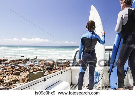 Boy surfer and father standing on back of truck looking out to sea, rear view, Cape Town, Western Cape, South Africa View Large Photo Image Stock Photo - Boy surfer and father standing on back of truck looking out to sea, rear view, Cape Town, Western Cape, South Africa. Fotosearch