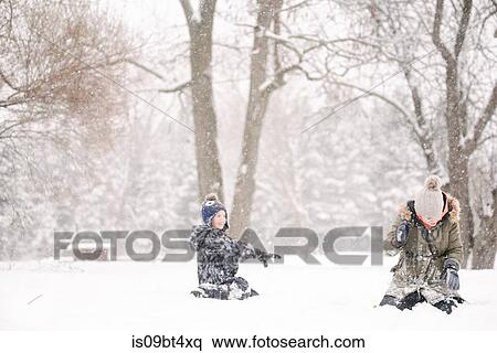 Boy throwing snowball at sister View Large Photo Image Stock Photography - Boy throwing snowball at sister. Fotosearch