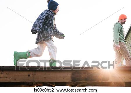 Boy with father running across sunlit skateboard ramp, low angle view View Large Photo Image Stock Image - Boy with father running across sunlit skateboard ramp, low angle view. Fotosearch