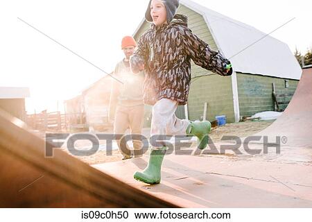 Boy with father running on sunlit farmyard skateboard ramp View Large Photo Image Stock Image - Boy with father running on sunlit farmyard skateboard ramp. Fotosearch