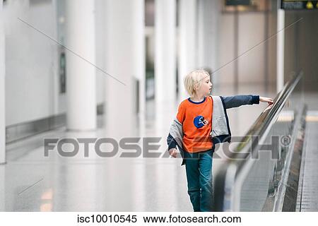 Boy with hand on handrail of moving walkway in airport, selective focus View Large Photo Image Stock Photography - Boy with hand on handrail of moving walkway in airport, selective focus. Fotosearch