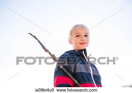 Boy with stick against clear white sky View Large Photo Image Stock Photo - Boy with stick against clear white sky. Fotosearch