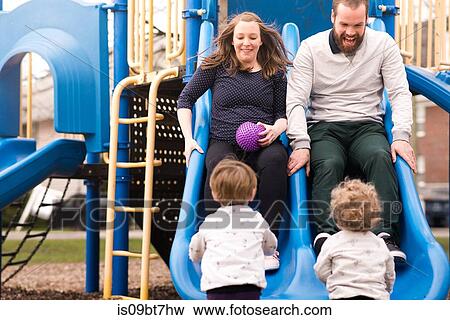 Boys looking at parents playing on slide View Large Photo Image Stock Photo - Boys looking at parents playing on slide. Fotosearch