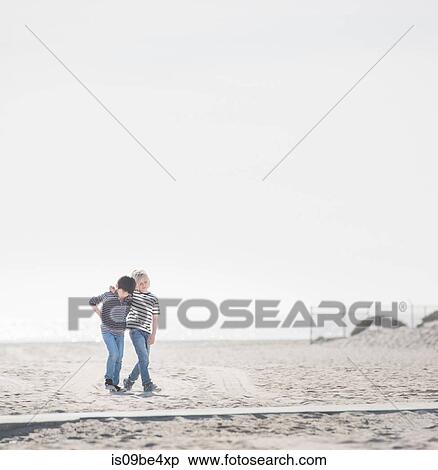 Boys walking on sandy beach View Large Photo Image Stock Photography - Boys walking on sandy beach. Fotosearch